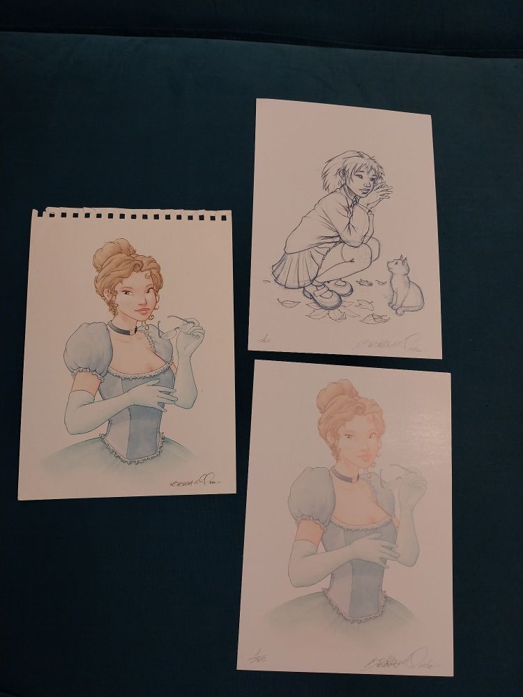 Aquarelle originale format A5 d'une jolie jeune femme, vêtue d'une robe de style ancien et de gants, le tout dans des tons bleus pastel. La femme tient élégamment une paire de lunettes dans la main gauche et semble regarder dans votre direction.
À côté de l'aquarelle, un ex-libris de la même aquarelle, et un ex-libris d'un crayonné d'une jeune femme accroupie devant un chat qui la regarde.