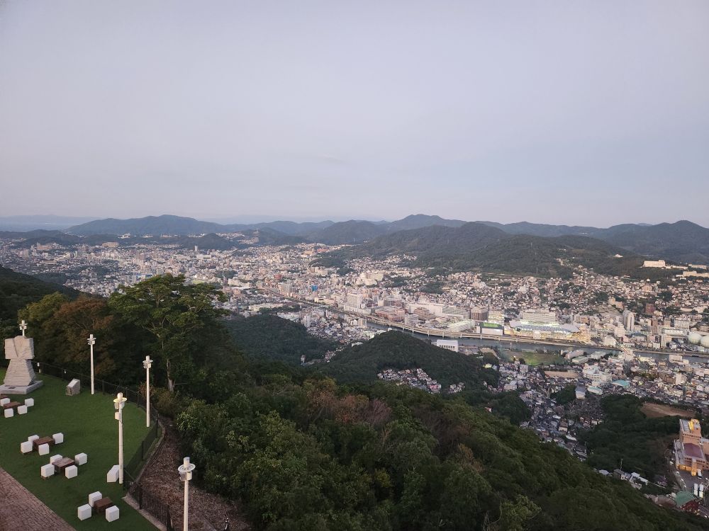 The view of modern-day Nagasaki from a lookout area, full of buildings and greenery