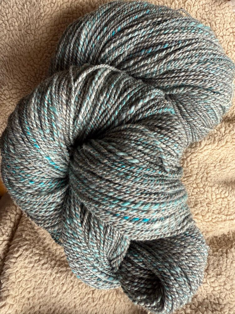 Skein of yarn turned on itself. Woolenspun in teals & gray