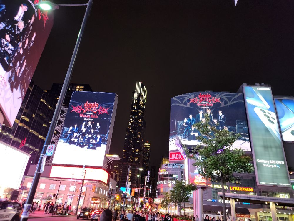 Photo shows ginormous billboards downtown Toronto at Sankofa (Dundas) Square promoting the Stray Kids dominATE tour.