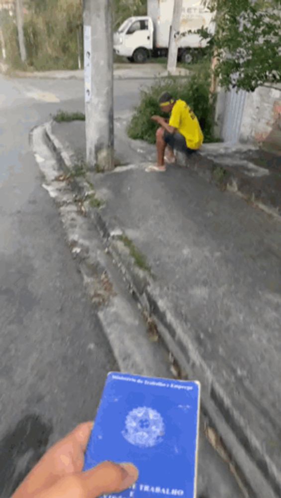 a man in a yellow shirt is sitting on a curb next to a truck that says pete on it