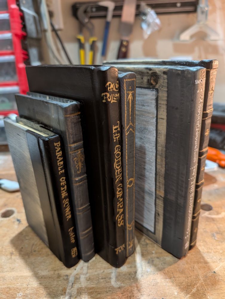 A view of the titles Parable of the Sower, The Golden Compass, and Tolkien's sigil