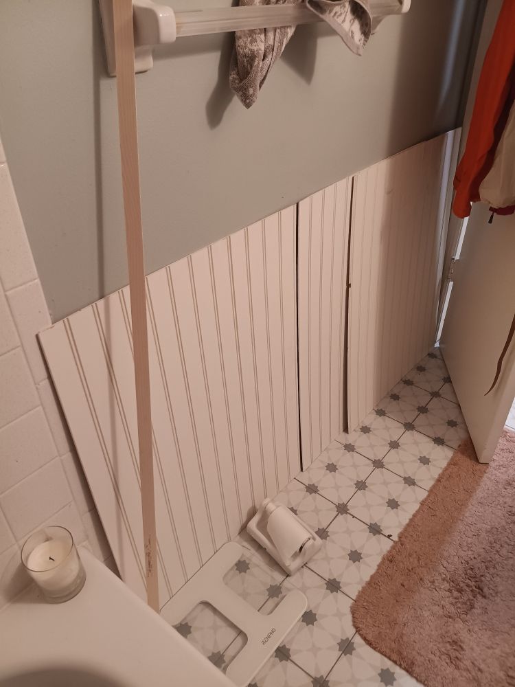 Photo of my bathroom with some panels of beadboard leaning against the wall.