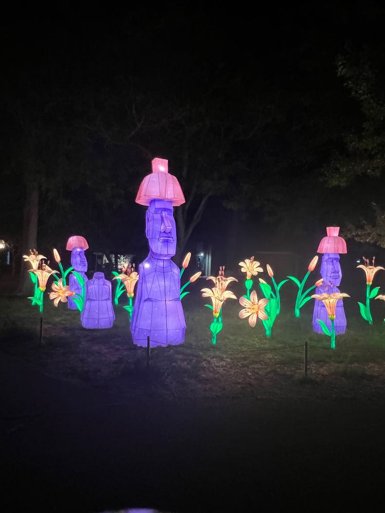 Stylized illuminated moai surrounded by lillies