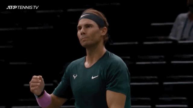 a man wearing a headband and a green nike shirt stands in front of an atp tennis tv screen