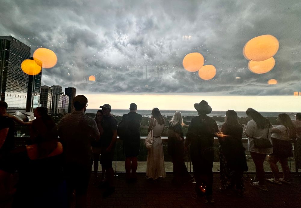 photo from inside a rooftop cocktail lounge overlooking Millennium Park as a storm cloud approaches 