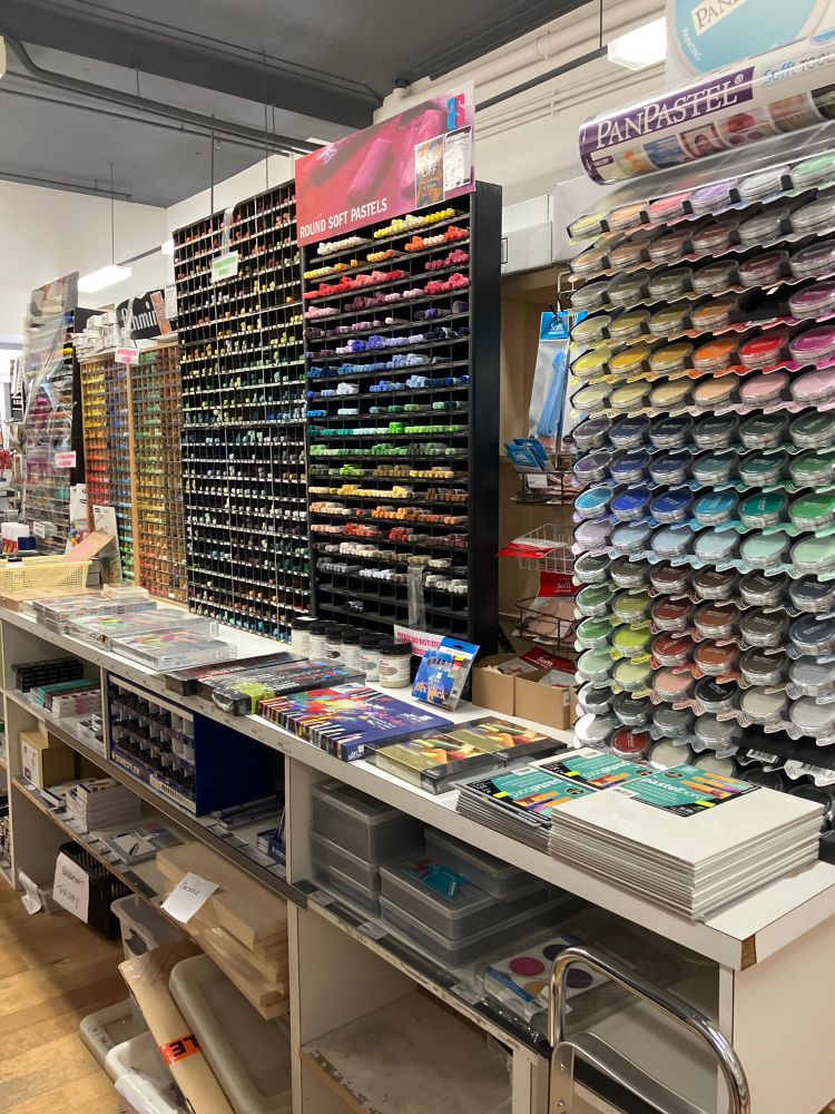 The top of a storage desk holds four separate display cabinets full of color pastels.