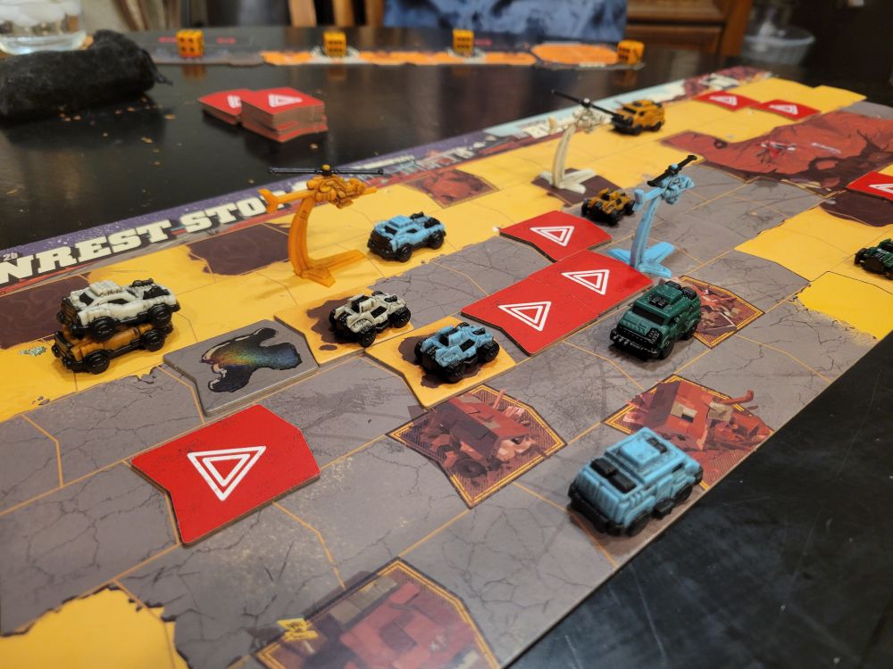 Miniature cars and helicopters on cardboard map of Australia.