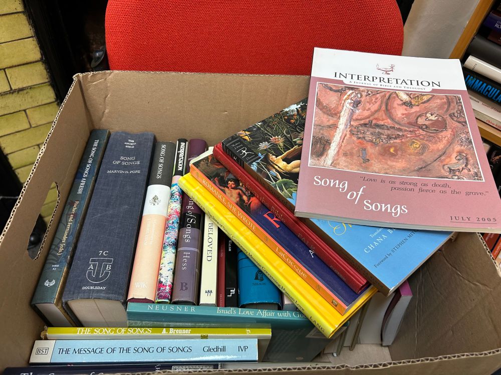 A large cardboard box filled with academic books on “The Song of Songs”