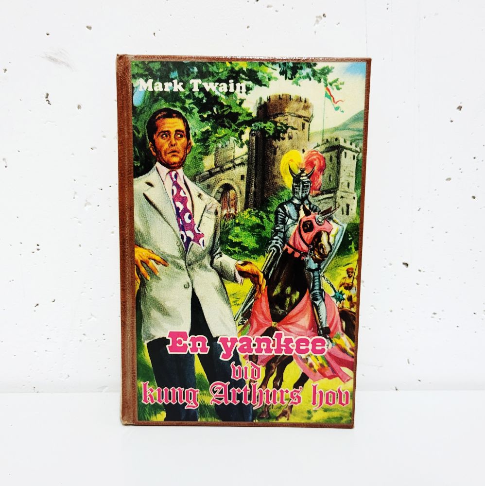 Boken En yankee vid kung Arthurs hov. Omslaget föreställer en slipsklädd man som ser förskräckt ut och en riddare på en häst. 