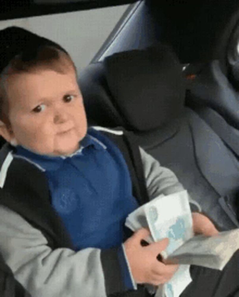 a young boy is sitting in the back seat of a car holding a stack of money