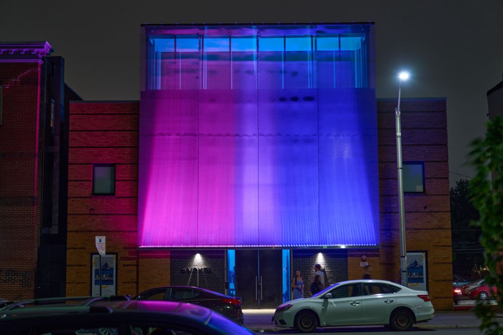 The Voxel facade lit up in the bi pride colors.