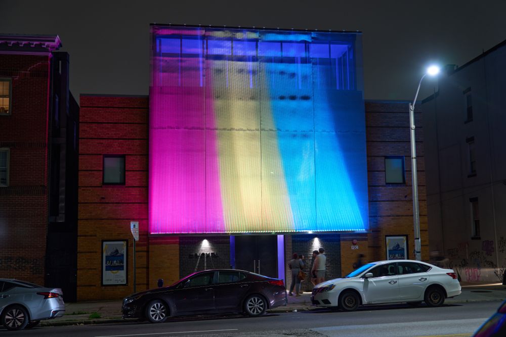 The Voxel facade lit up in the pansexual pride colors.