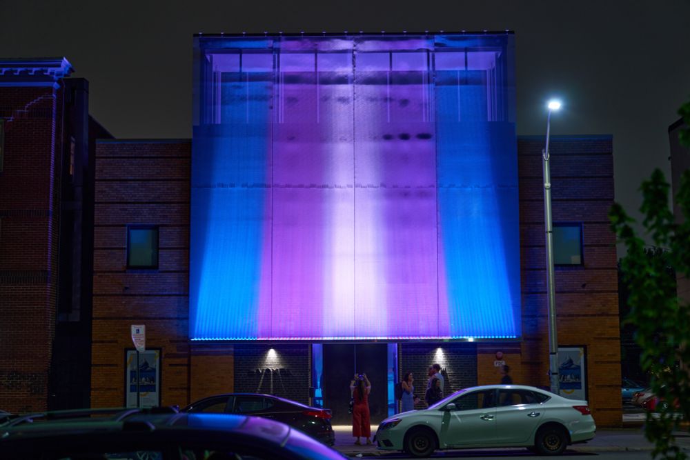 The Voxel facade lit up in the trans pride colors.