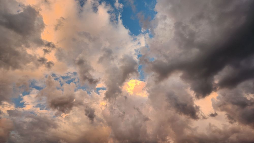 Sunset before a storm with yellow, pink, and dark gray clouds