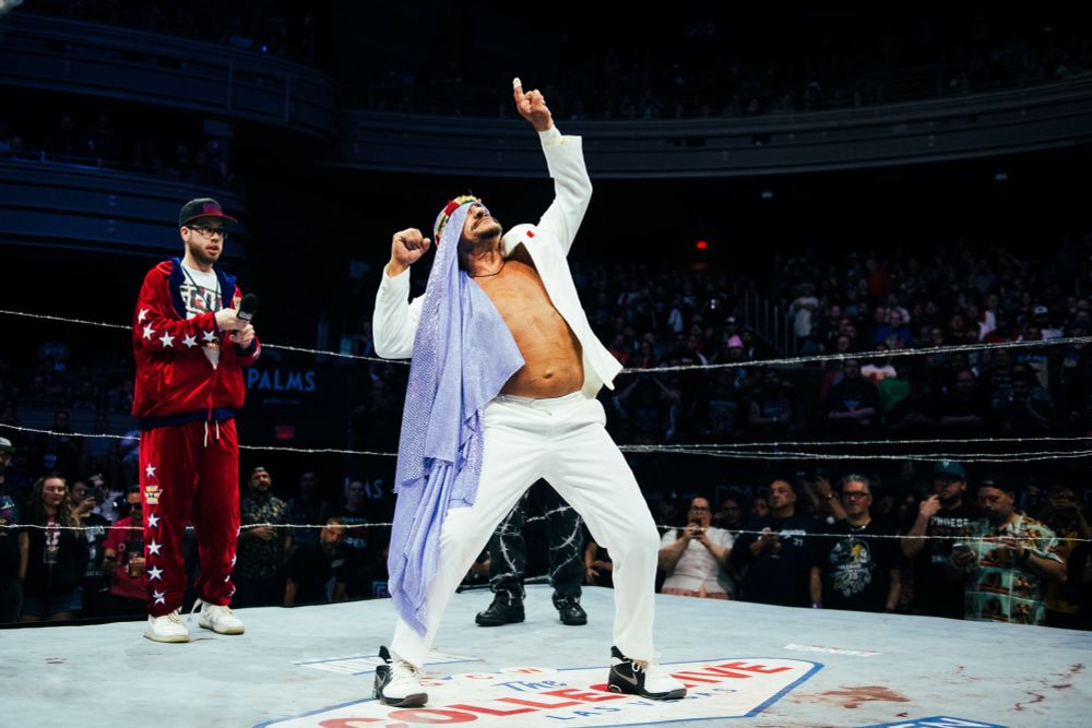 the wrestler SABU in the center of a ring pointing to the sky
