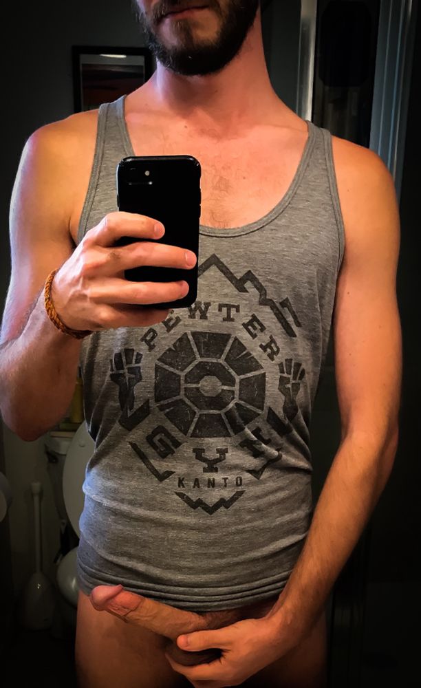 In just a tank top holding my package by my balls. For some reason, I look way more muscular than I actually am.