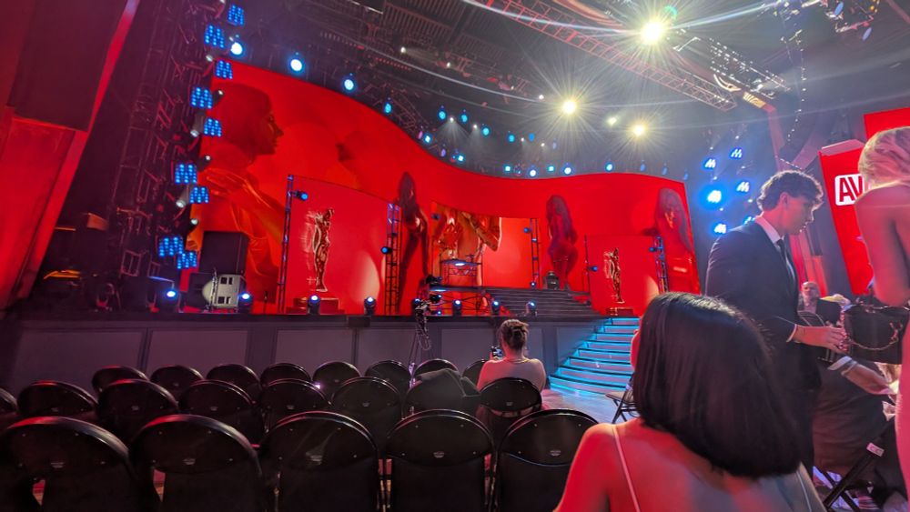 A large stage set with orange video panels, arranged in a wave pattern