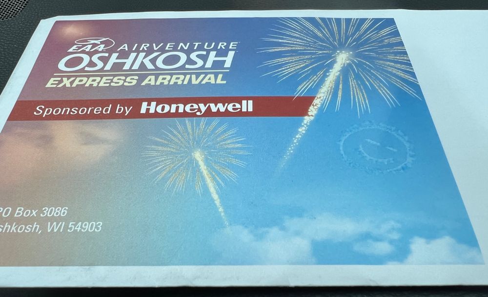 Envelope with Oshkosh 2025 tickets and wristband.