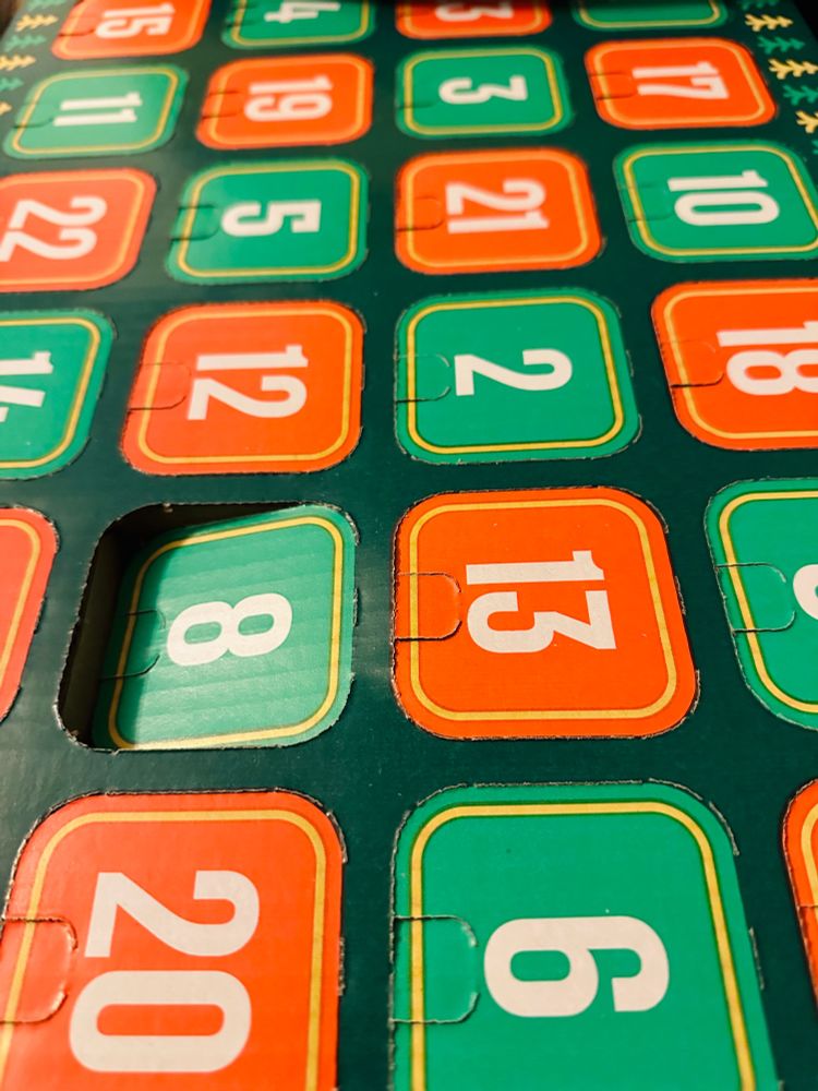 A photograph of the red and green coloured doors of a large advent calendar for beer, with the door for number 8 already prised open. 