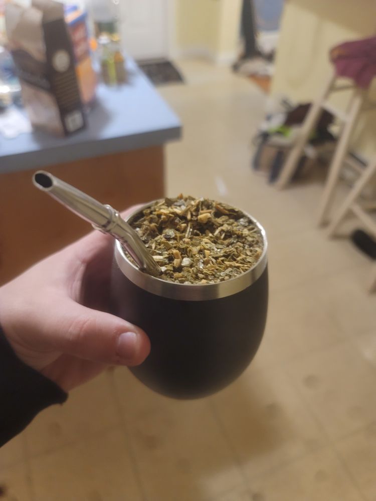 a stainless steel gourd filled with mate and a bombilla.