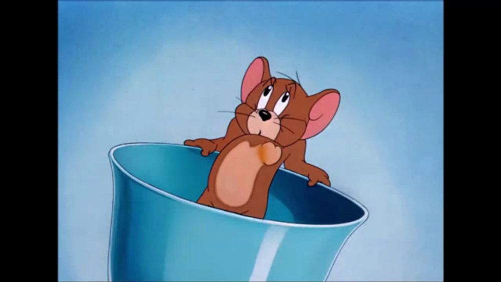 a cartoon mouse is sitting in a blue bowl