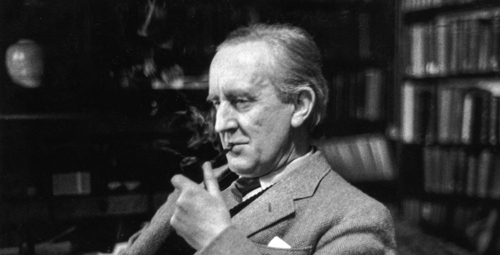 A black and white photo of an old Tolkien, with white hair. He's wearing a suit, sitting in his office, smoking his pipe, with a thinking semblance.