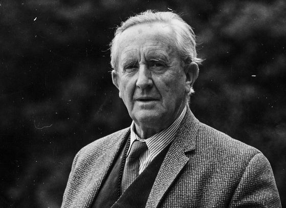 A black and white photo of an old Tolkien, with white hair. He's outdoor, wearing a suit, looking directly into the camera with a neutral semblance.