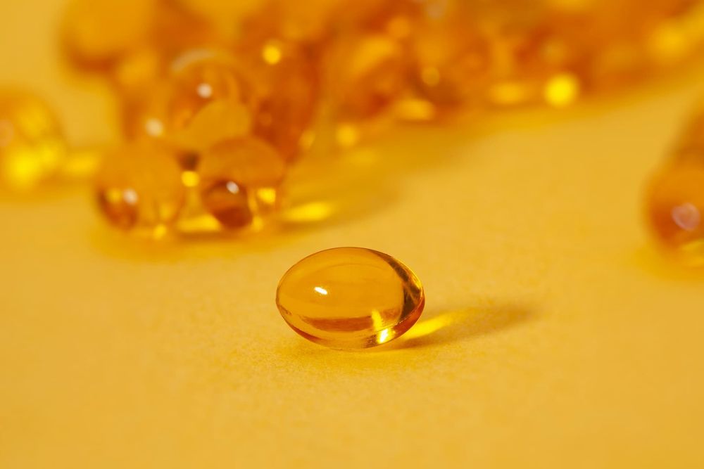 A close up image of a vitamin d capsule on a yellow background