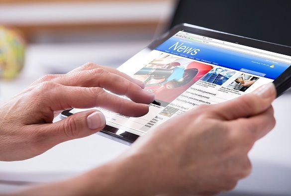 a person is reading the news from their tablet