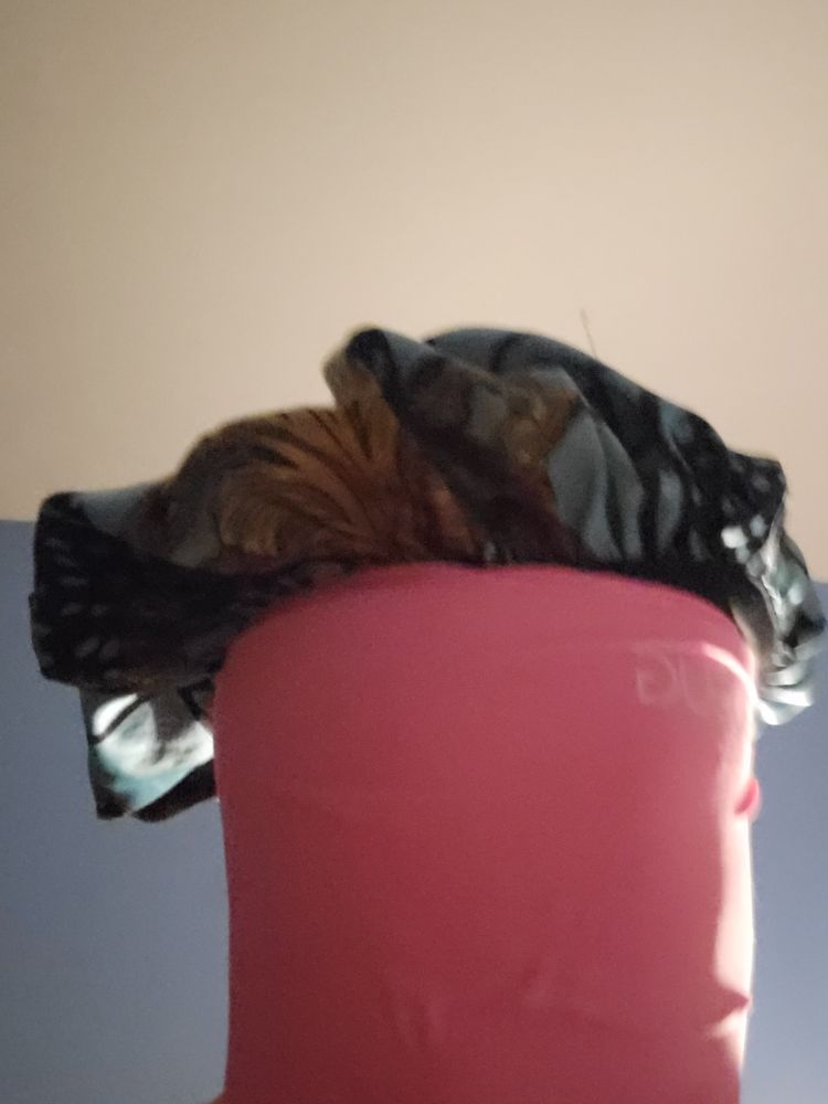 A selfie of me wearing a migraine cap that completely obscures my face, with a satin bonnet sticking out from the top