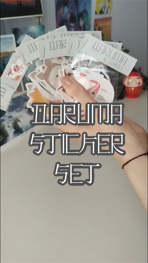 A hand holding seven small plastic bag with stickers