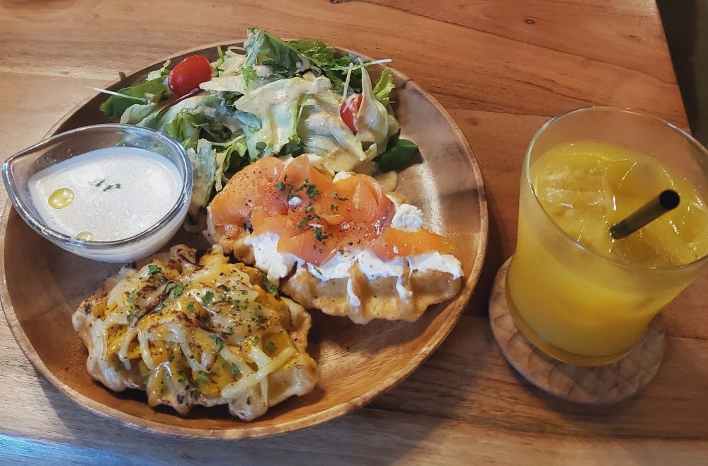 プレートに盛られたクロッフルとスープ、横のマンゴージュース