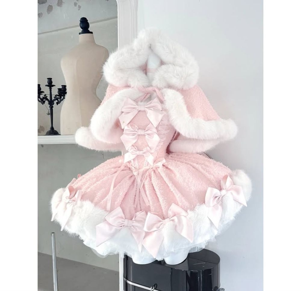 Pale pink short dress with bows on a mannequin with a faux fur lined accompanying cape