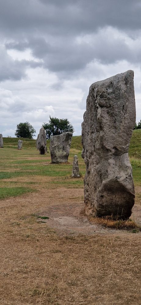 A row of standing stones under a cloudy sky.