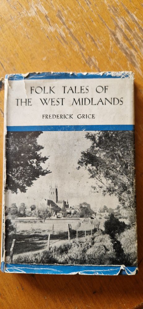 Old book with tattered dust jacket on a wooden table. 