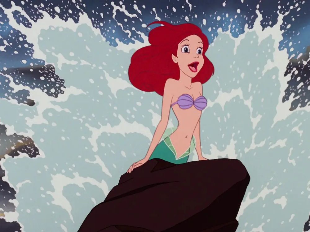 Disney’s Ariel from The Little Mermaid posing dramatically on a rock