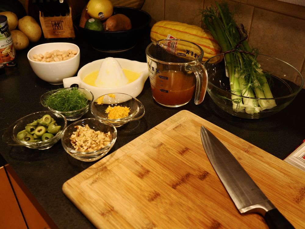 Mise en place and my chopping board and knife. Featuring stock in a Pyrex measuring cup, freshly squeezed orange juice in my vintage Sunkist reamer, cannellini beans, fennel fronds, orange zest, chopped walnuts, and sliced castelvetrano olives 