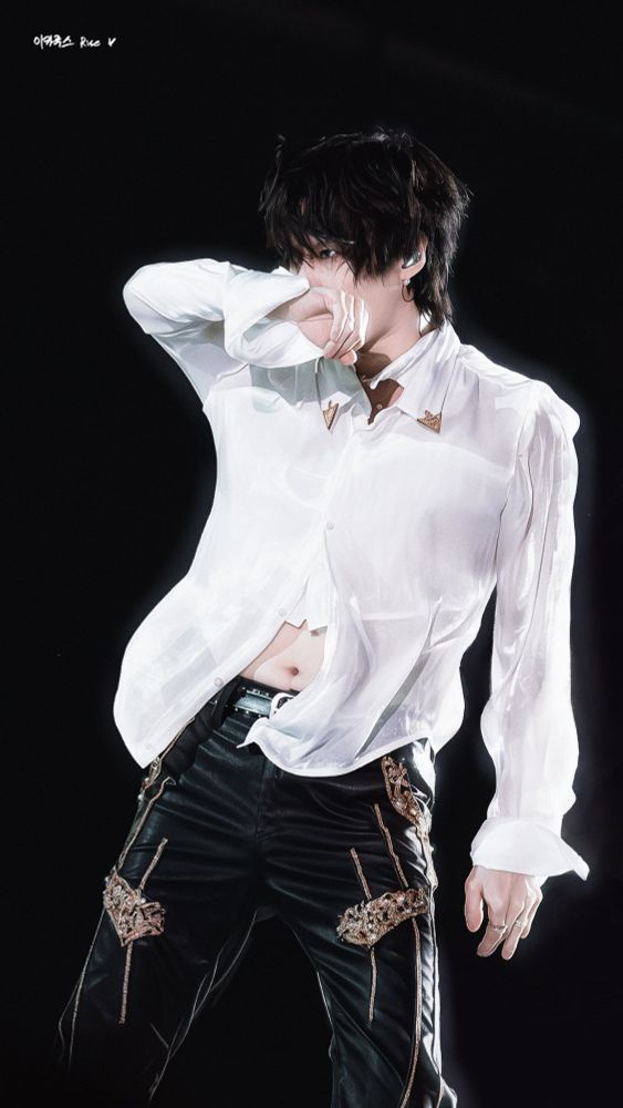 taemin at show! musiccore in japan. he's wearing a white sheer shirt, his right arm covers his face and the shirt is half open to reveal his navel. photo by rise6v6
