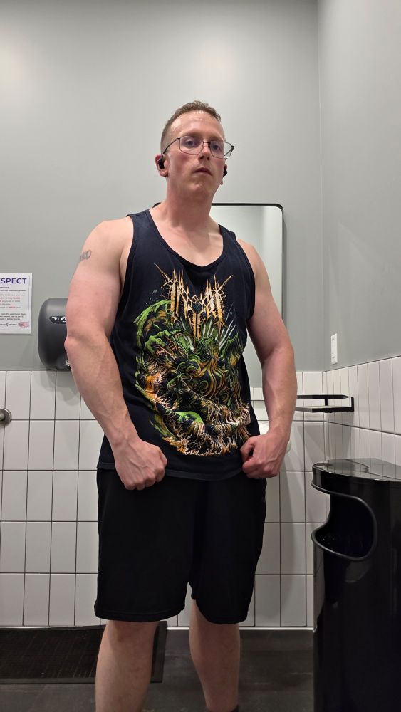 Me, wearing black shorts and an Inferi tank top, with a post weight-lifting pump and vascular foreaems