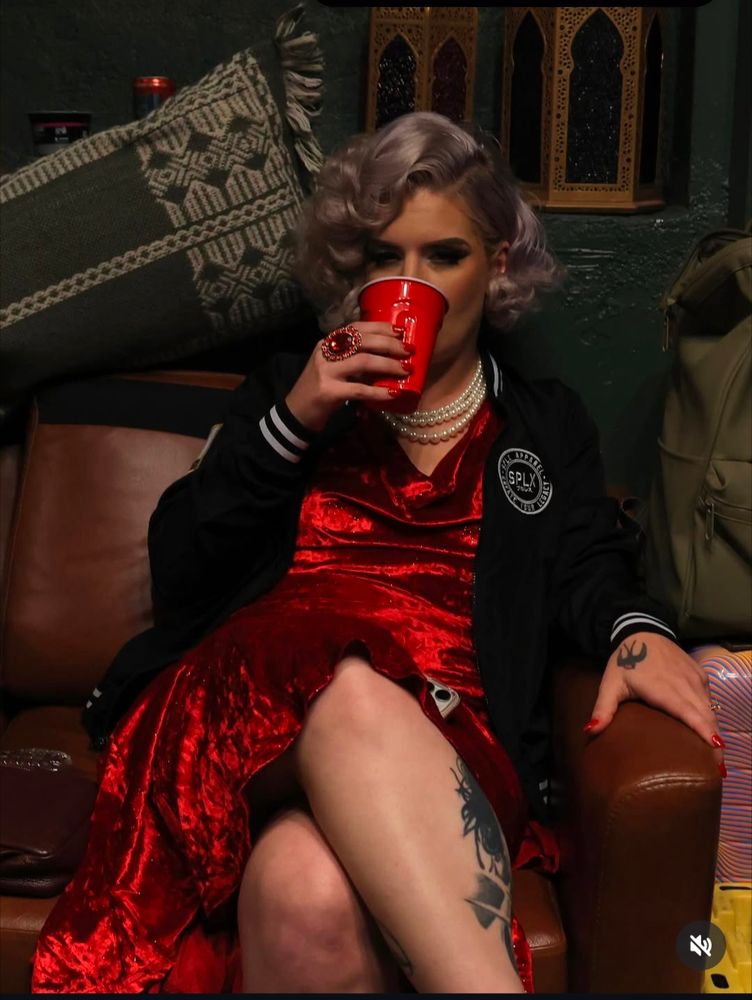 Timeless Toni Storm sitting down on a couch drinking something from a red cup