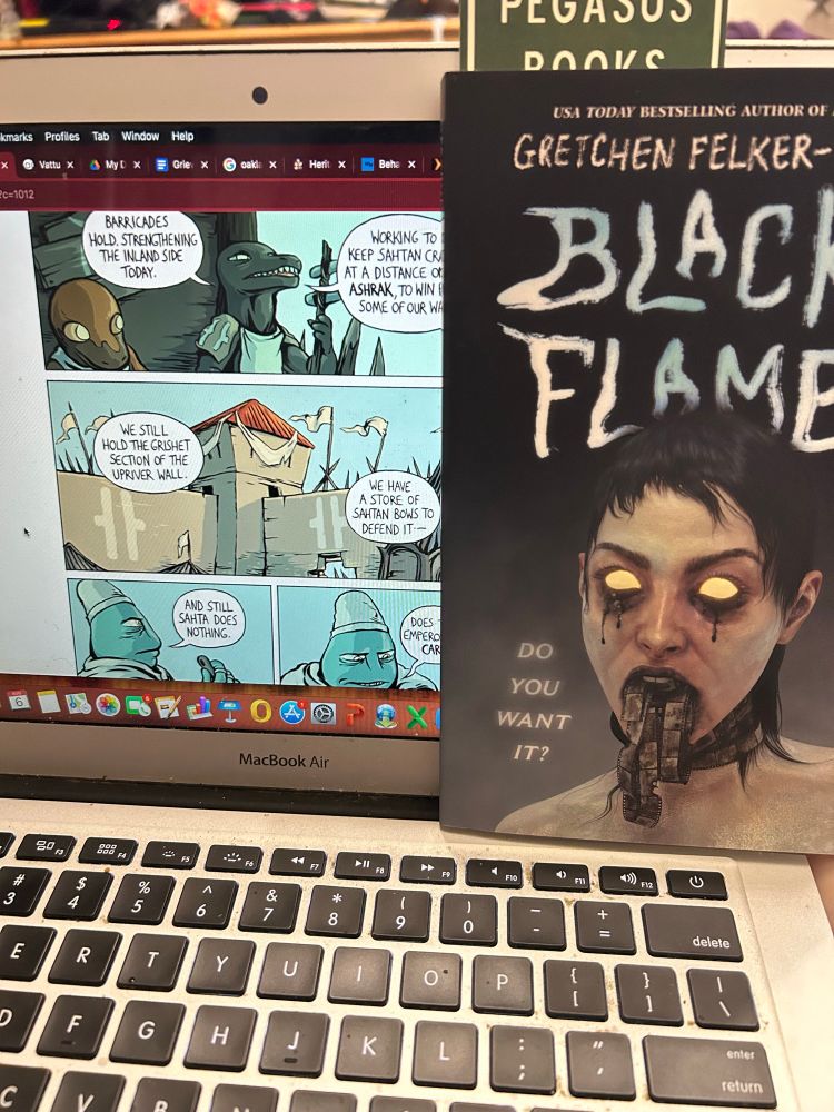 She is reading Vattu on her laptop, which is holding up a copy of Gretchen Felker-Martin’s new novel Black Flame