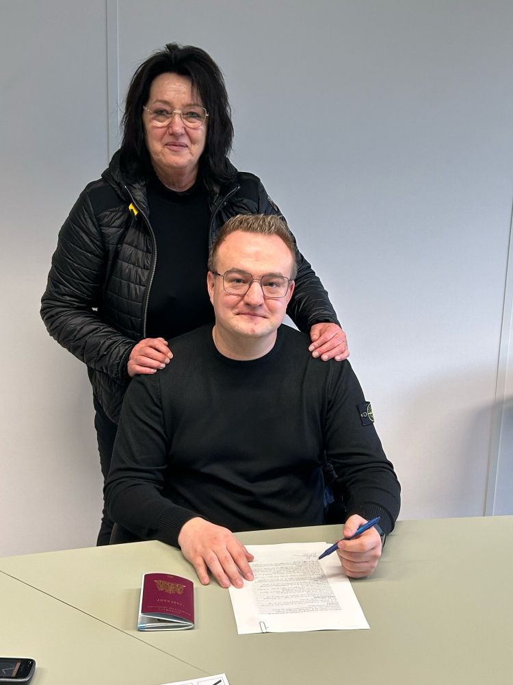 A photo of my mother and I at the civil notary, where I sign the deed of transfer of the plot of land on which she lives.
