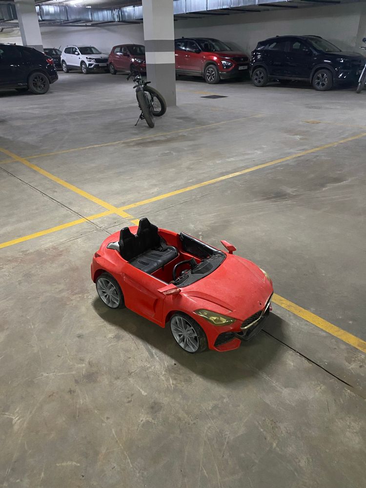 A child’s toy car parked in one of the parking spots for my building