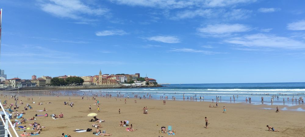 Playa de San Lorenzo, en Gijón. Bajamar. Cielo azul, prácticamente despejado.