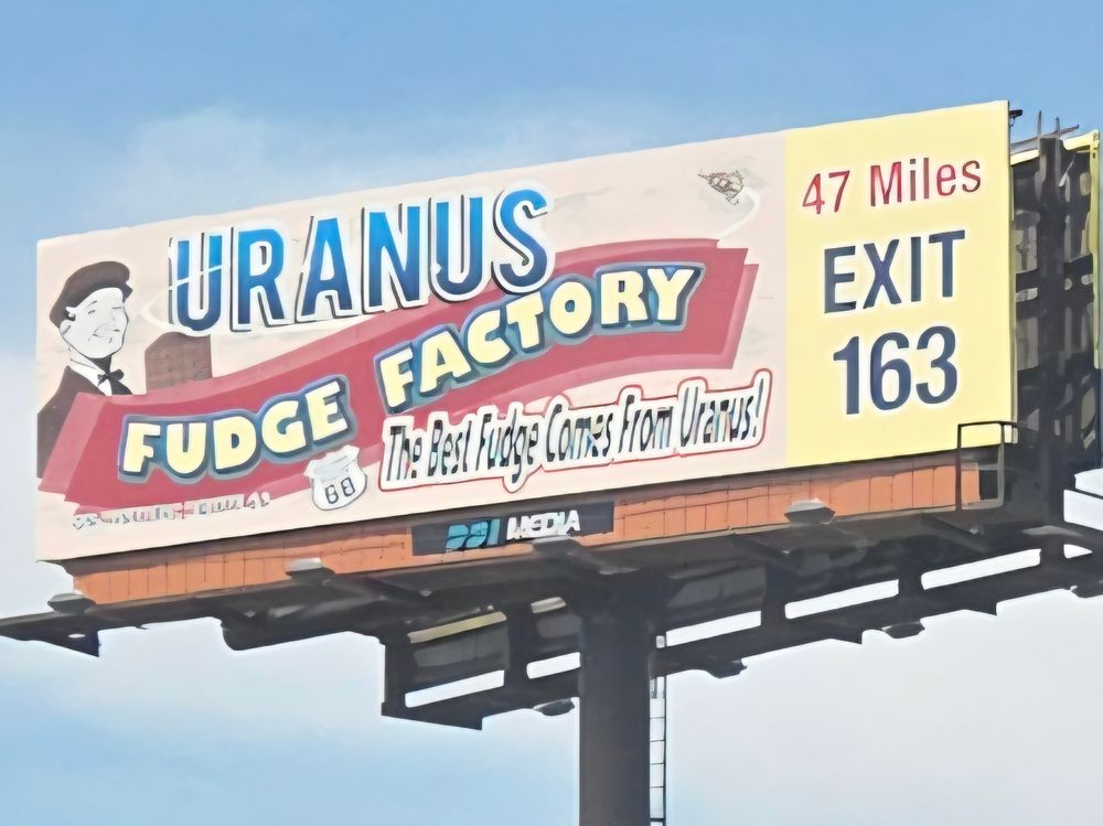 Billboard with a vintage gentleman holding chocolate:

URANUS FUDGE FACTORY
The Best Fudge Comes From Uranus!

47 Miles
EXIT 163
