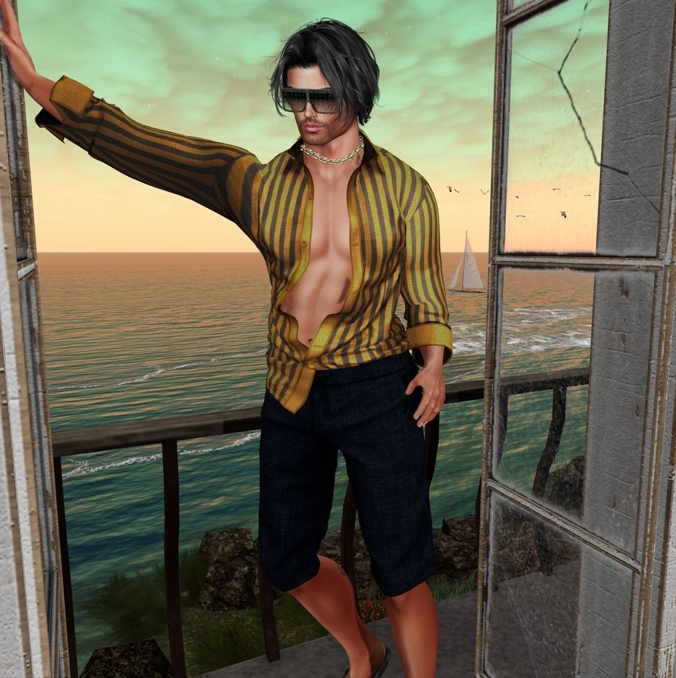 Male #Secondlife avatar leaning on a patio doorway overlooking the ocean in an opened navy and yellow striped shirt and navy shorts.