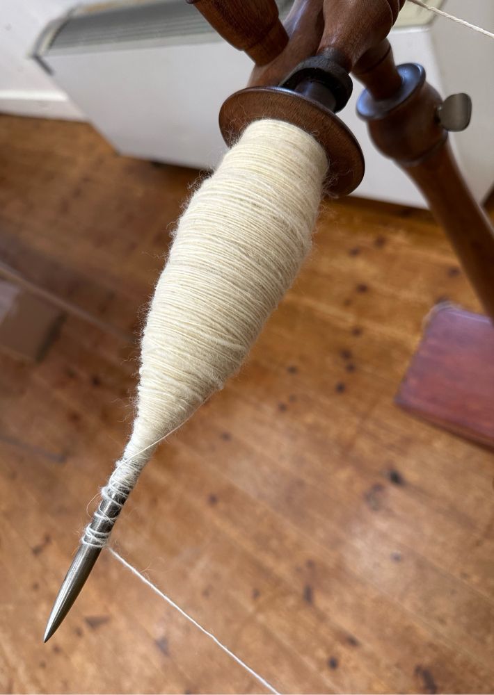 The spindle of a great wheel, with a cop of white wool in a more bulbous formation than would be ideal!
#handspinning #handspun  #spinningyarn #handspunyarn #spinning #spinster #yarnspinning #greatwheel #walkingwheel