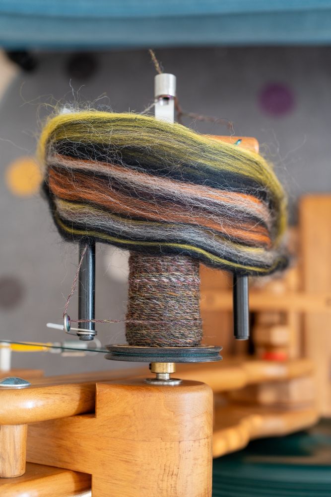 The same yarn, but with the fibre it was spun from. The top contains bright yellow and orange along with black and white. 
