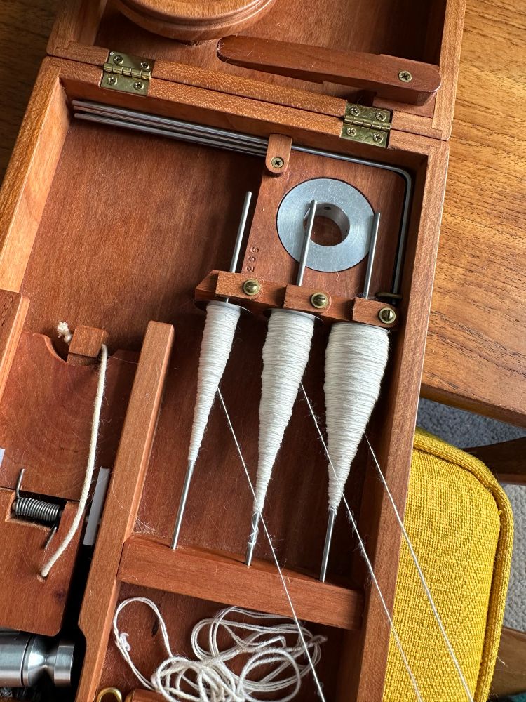 Three spindles of handspun cotton single mounted in the built-in lazy Kate of a Bosworth book charkha. Imagine baby bear, mummy bear and daddy bear in cop form and you’re pretty much there! Handspinning 